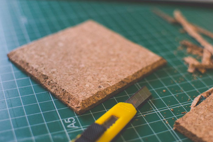 A close-up of a coaster being trimmed on a cutting mat as an idea for what to do with photos