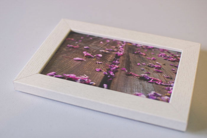 A photograph of pink flowers in a wooden frame as an idea of what to do with photos