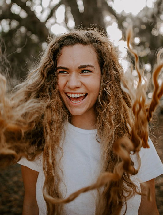 Portrait of a blond girl, her hair flying towards the camera. Self portrait photography tips.