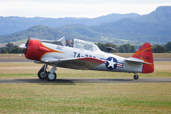 An airshow photography shot of a red and white airplane taxiing on the runway