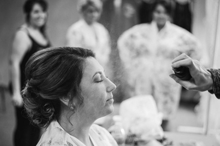 A black and white photo of a bride getting her make up done