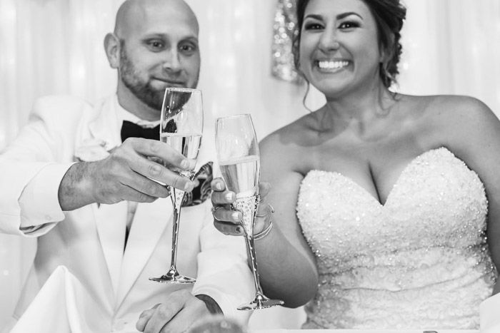 black and white wedding photo of a newlywed couple toasting with champagne