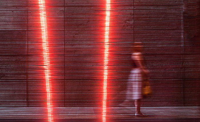 A color street photography shot of a woman walking past artwork 'Aeriology' by David Haines and Joyce Hinterding. black and white vs color street photography. 