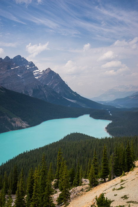 A stunning scenic shot of a blue lake surrounded by forest- make money with travel photography