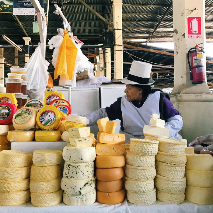 Documentary photography of a woman in a cheese market processed with VSCO with c3 preset. Instagram tips for social media photography.