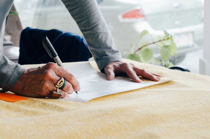 A close up shot of a man writing a model release from for photography.