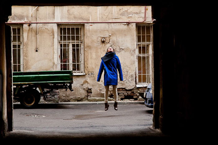 A natural light photography portrait of a girl jumping in the yards of Saint Petersburg 