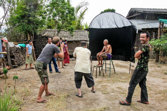  A Karen man posing in an outdoor portrait photography studio for photographers and onlookers.