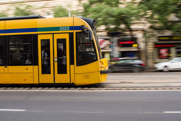 A shot of a yellow tram moving on the street