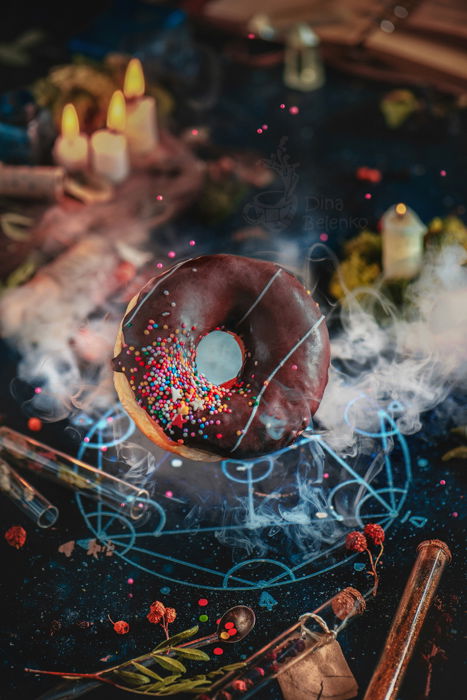 Still life photography ideas of flying chocolate glazed donut summoned with an alchemical pentagram 