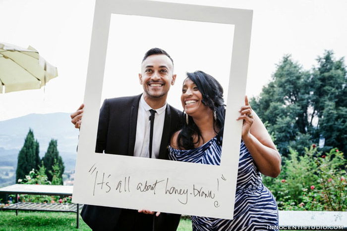 an image of a wedding couple using a large Polaroid Frame as a photo booth