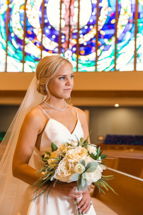 A portrait of the bride holding flowers in the church - photography lights