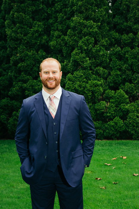 A photo of the groom posing in garden - natural wedding photography lighting