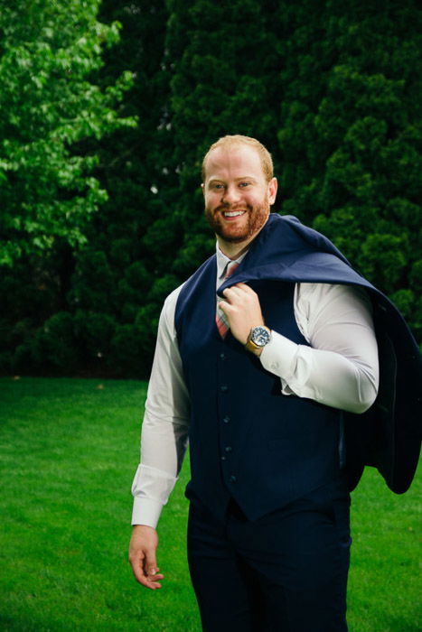 A photo of the groom posing in garden - natural wedding photography lighting