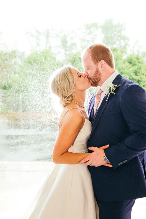 A photo of the newlywed couplekissing outdoors - wedding photography lights