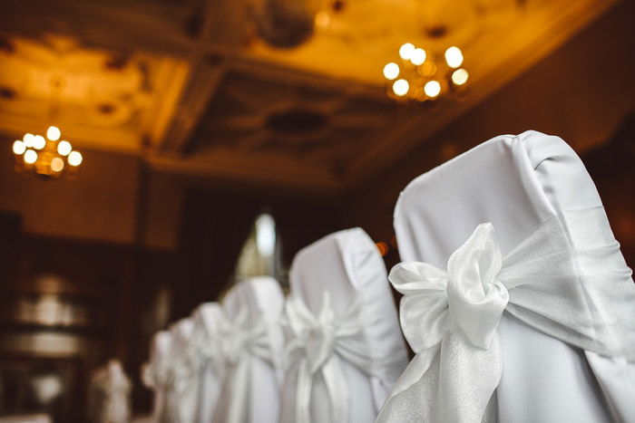 A row of chairs decorated for a wedding ceremony. 