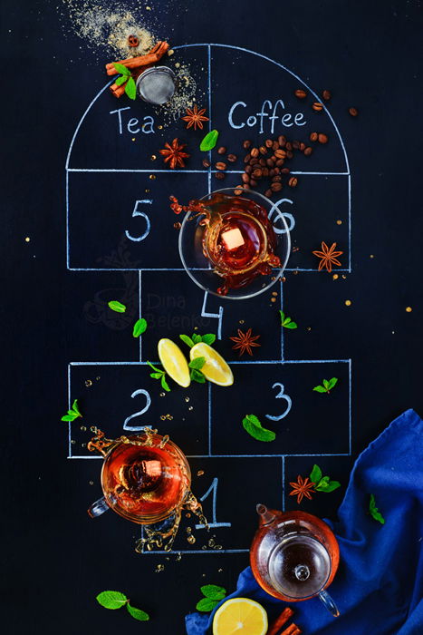 An overhead creative coffee photo shot of the game hopscotch created with coffee cups, cinnamon sticks and spoons