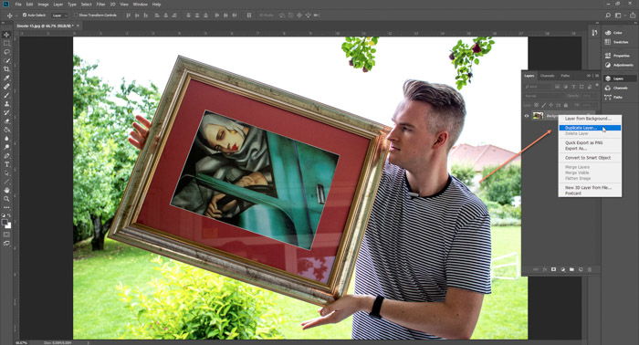 Screenshot of Photoshop editing a picture of a man holding a framed painting