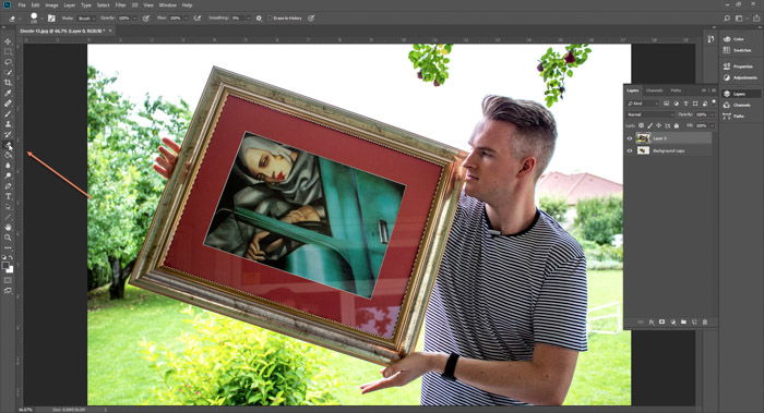 Screenshot of Photoshop editing a photo of a man holding a framed painting - droste-effect step eight