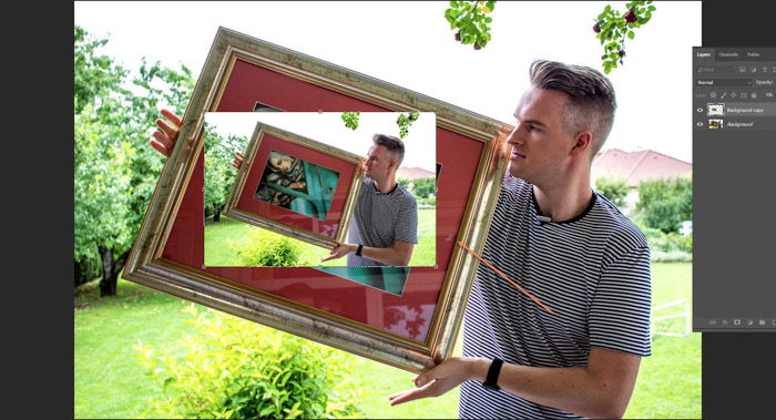 Screenshot of Photoshop editing a photo of a man holding a framed painting