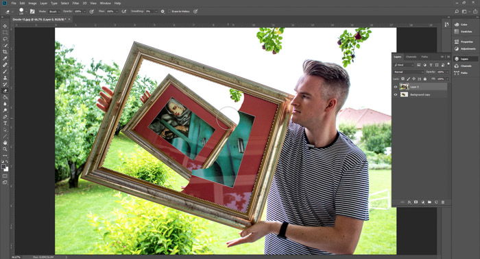 Screenshot of Photoshop editing a photo of a man holding a framed painting - droste-effect step nine