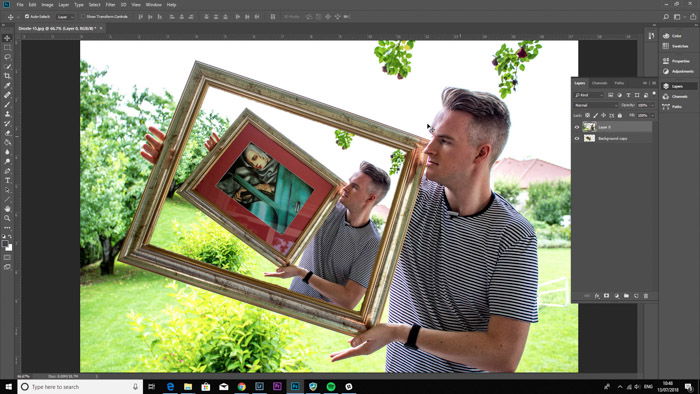 Screenshot of Photoshop editing a photo of a man holding a framed painting - droste effect step ten