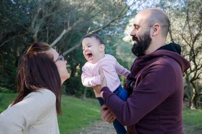 Casual lifestyle family portrait of a couple holding a small baby - family photos composition tips