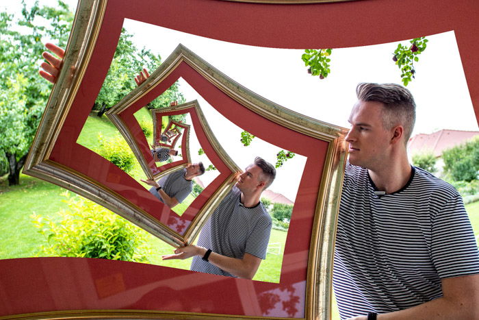 The final image of a man appearing to hold a photo within a photo within a photo