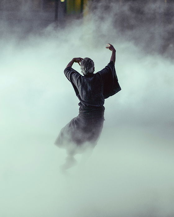 Atmospheric fine art photography portrait of a person dancing in the midst of smoke or fog