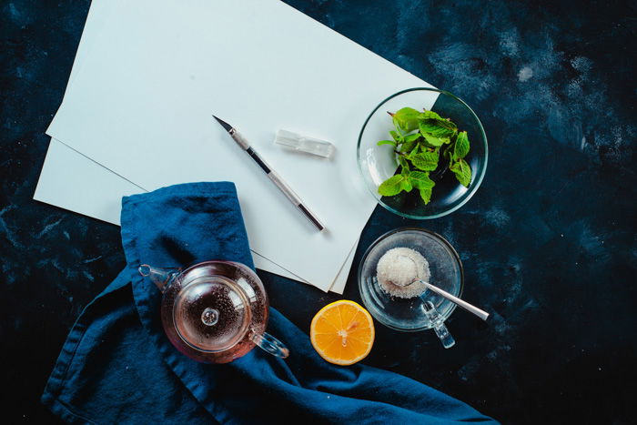 An overhead shot of paper, glassware, fruit and other food art props needed to create our final shot