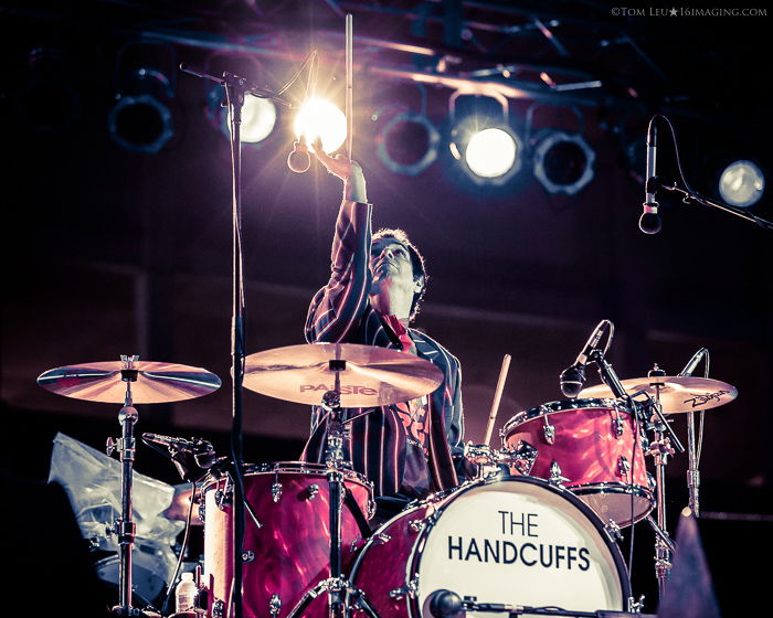 A music photography live shot of a drummer playing onstage