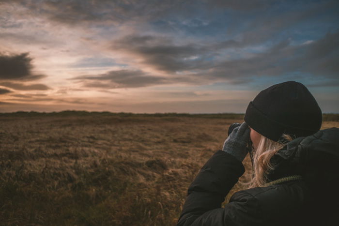 A nature photographer taking an evening landscape shot