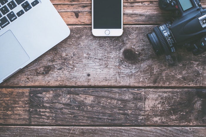 Overhead shot of photography equipment on a wooden table - photography insurance tips