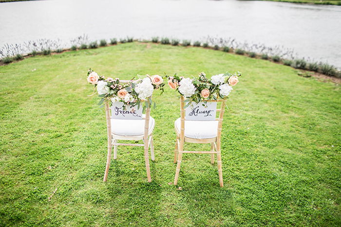 A bright and airy photo of two decorated wedding chairs to be used as wedding portrait backgrounds