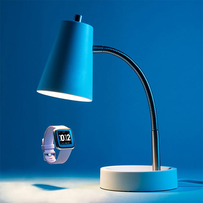 A floating watch under a blue lamp