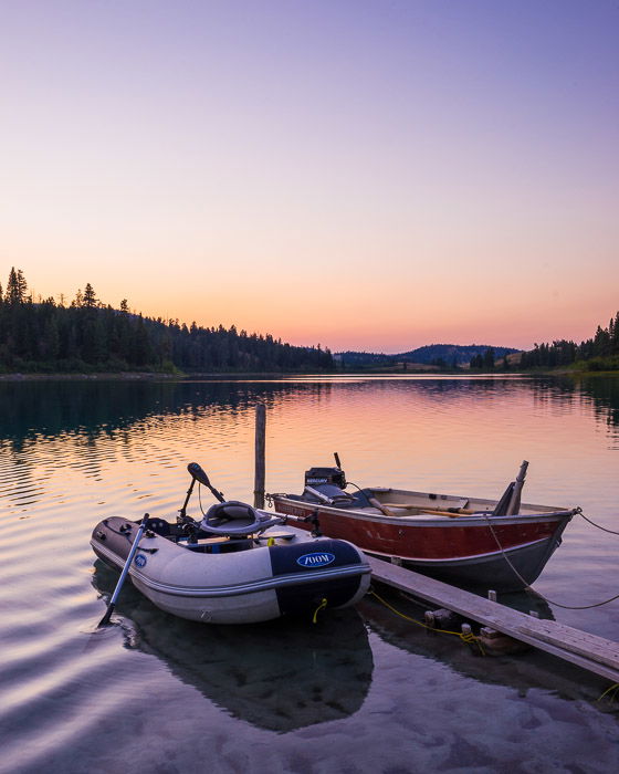 A road trip photography shot of two small boats tied up on a lake at evening 