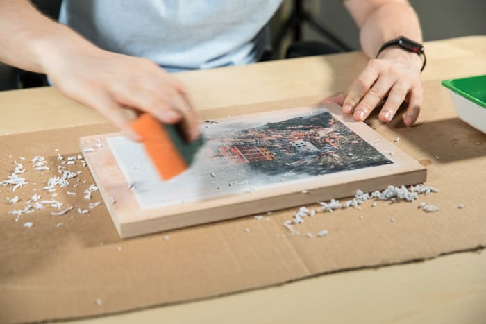 A man preparing a wooden board to transfer photos to wood