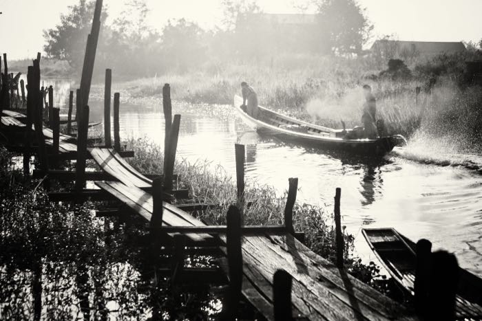 Striking monochrome travel images of a wooden bridge and small boat