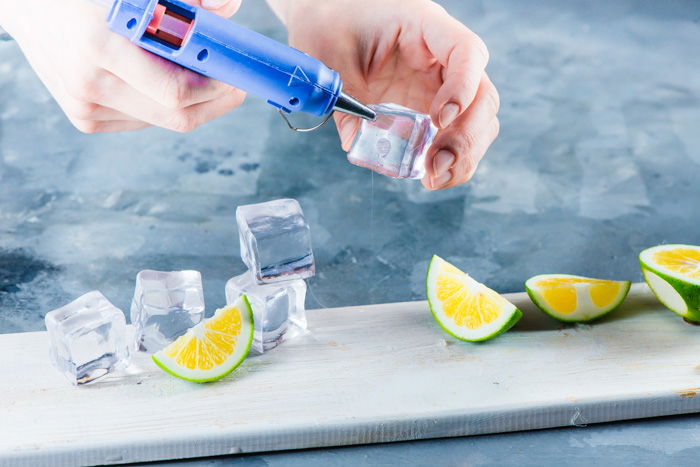 Set up for water splash photography with acrylic ice cubes, limes and glue gun 