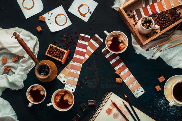 A barista themed still life flat lay with coffee cups, color charts and other brewing utensils 