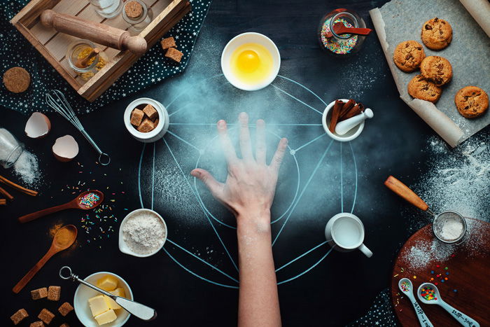 Occult themed food photography flat lay still life with a hand and food items on dark surface