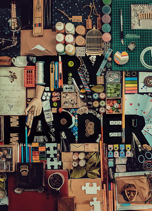 A creative still life flat lay idea with the silhouette of the word 'Try Harder' comprised of many small objects