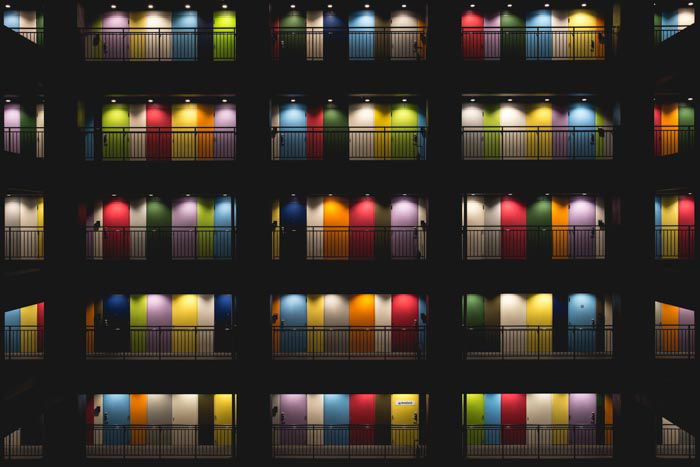 A photo of the interior courtyard of an apartment block where each of the doors are brightly colored 