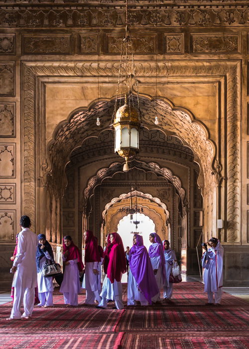 Human element in architecture photography: A group of people walking through Badshahi mosque in Lahore Pakistan