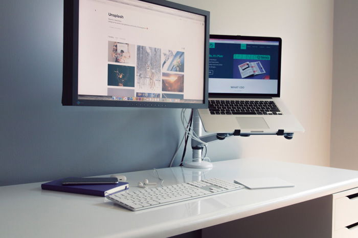 Editing monitor on a desk with macbook and external keyboard