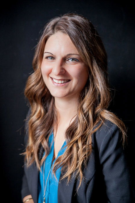 A business headshots of a woman against a dark background