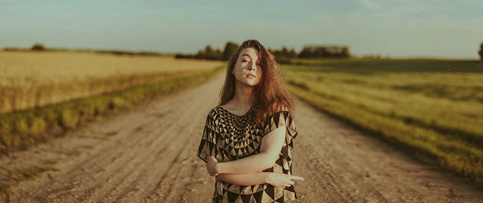 Beautiful close up portrait of a female posing on a country road shot using ambient light