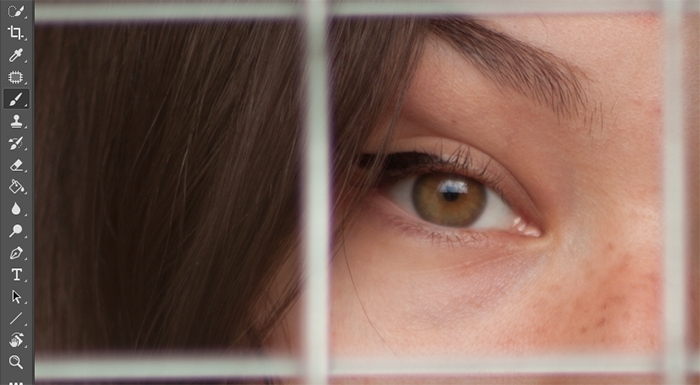 A close up of a girls eyes with a fence in front of her open for editing