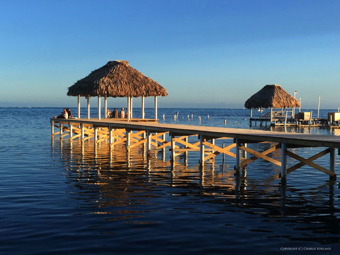 People sitting on a wooden pier by the ocean taken with iPhone photography camera