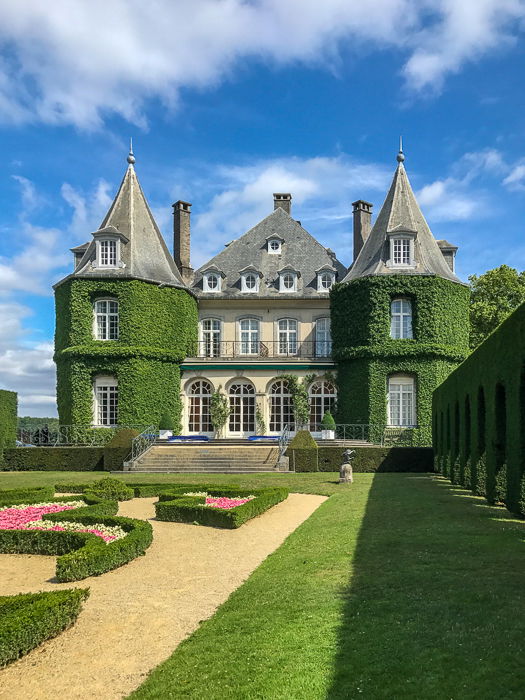 The Chateau de La Hulpe, near Brussels (Belgium), with vines covering its walls, against a cloudy blue sky. Shot with the iPhone 7.